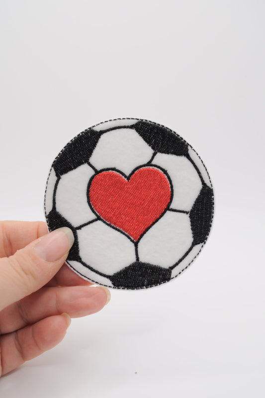 Flicken in der Form eines schwarz-weißen Fußball mit rotem Herz