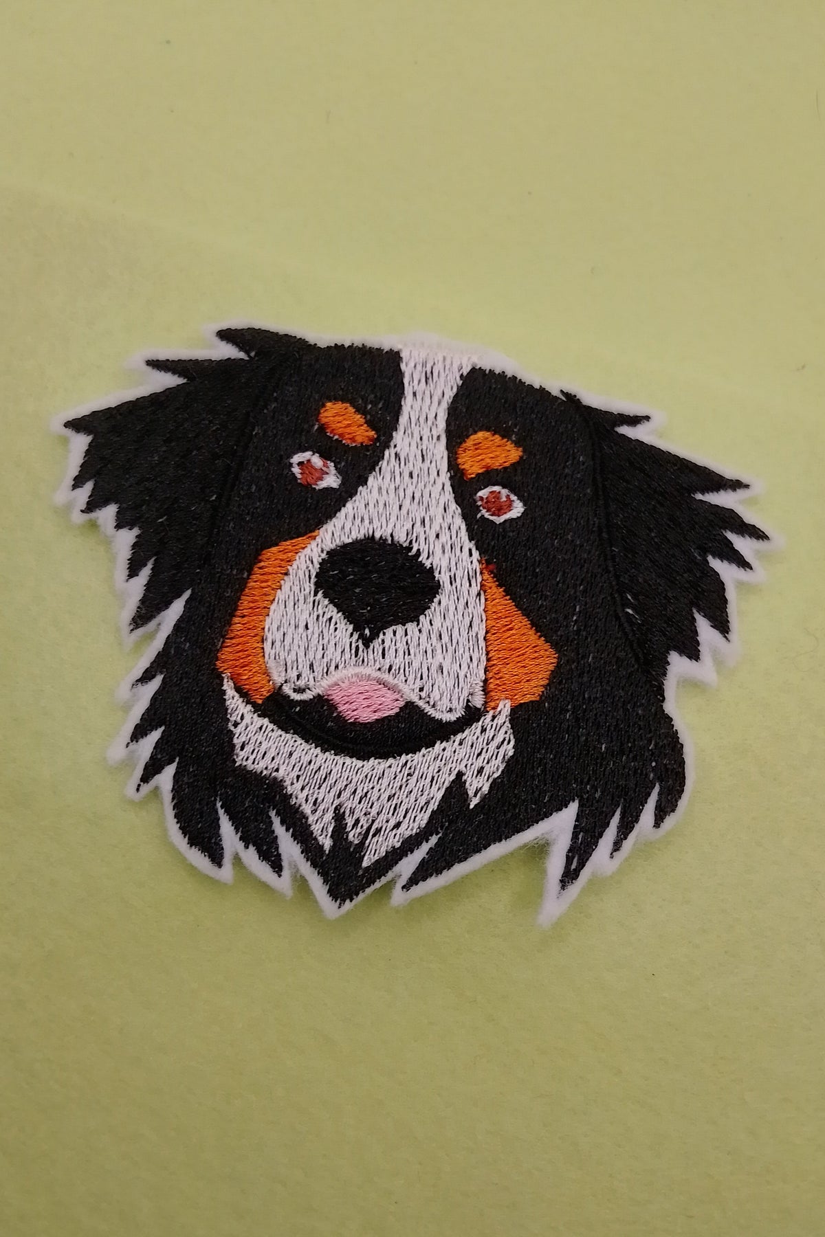 Ein Aufnäher in Hundekopf Form, Rasse Berner Senner